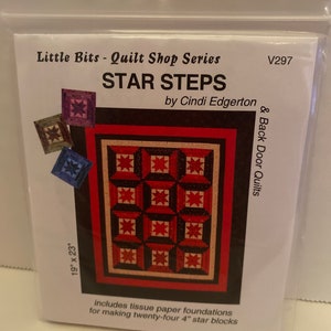 May include: A package for a quilt pattern titled "STAR STEPS" by Cindi Edgerton. The design features a red, black, and tan star pattern. The package dimensions are 19" x 23". Includes tissue paper foundations for making twenty-four 4" star blocks.