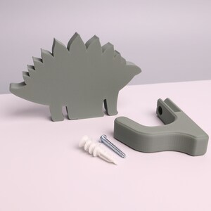 package contents - a green dinosaur, wall hook, mounting screw, wall anchor