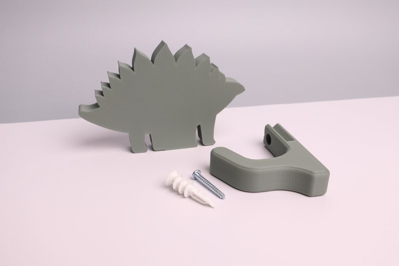 package contents - a green dinosaur, wall hook, mounting screw, wall anchor