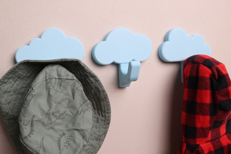 3 cloud wall hooks with a hat and coat hanging on them