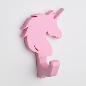 May include: A pink unicorn-shaped wall hook with a single hook on the bottom. The hook is made of plastic and is designed to look like a unicorn's head.