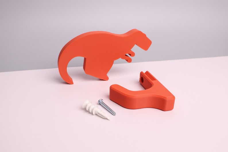 package contents - a red dinosaur, wall hook, mounting screw, wall anchor