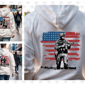 May include: White hooded sweatshirt with a graphic print of a soldier standing in front of an American flag. The soldier is holding a rifle and is wearing a helmet.