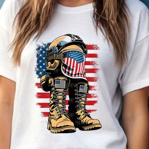 Op de afbeelding: Een wit T-shirt met een afbeelding van een militaire helm met een Amerikaans vlagontwerp en een paar bruine combatlaarzen.