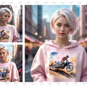 May include: A pink hoodie with a graphic print of a person riding a dirt bike. The print is in watercolor style and features a blue sky and brown dirt.