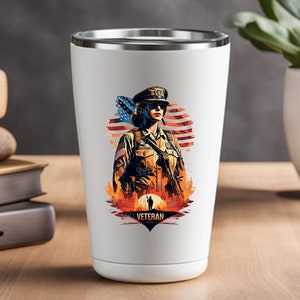 Op de afbeelding: Witte reistumbler met een afbeelding van een vrouwelijke soldaat in militaire uniform die voor een Amerikaanse vlag staat met de tekst "Veteran" eronder.