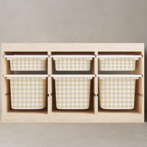 May include: A wooden storage unit with six compartments, each containing a beige and white gingham patterned bin with a white lid. The unit is made of light-coloured wood and sits on a neutral-coloured floor.