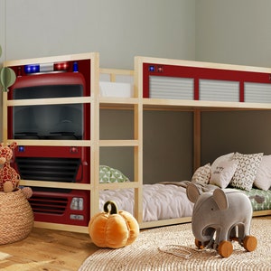 May include: A wooden bunk bed with a red fire truck design on the headboard. The top bunk has a white and gray patterned mattress and a gray elephant toy on the floor. The bottom bunk has a green and white patterned mattress.