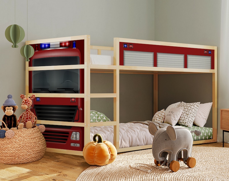 May include: A wooden bunk bed with a red fire truck design on the headboard. The top bunk has a white and gray patterned mattress and a gray elephant toy on the floor. The bottom bunk has a green and white patterned mattress.