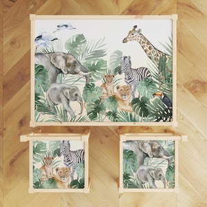 Può includere: Un set di tre tavoli in legno con tema animali della giungla. I tavoli presentano uno sfondo bianco con illustrazioni ad acquerello di elefanti, giraffe, zebre, leoni e tucani. I tavoli sono perfetti per la cameretta di un bambino o un'area giochi.