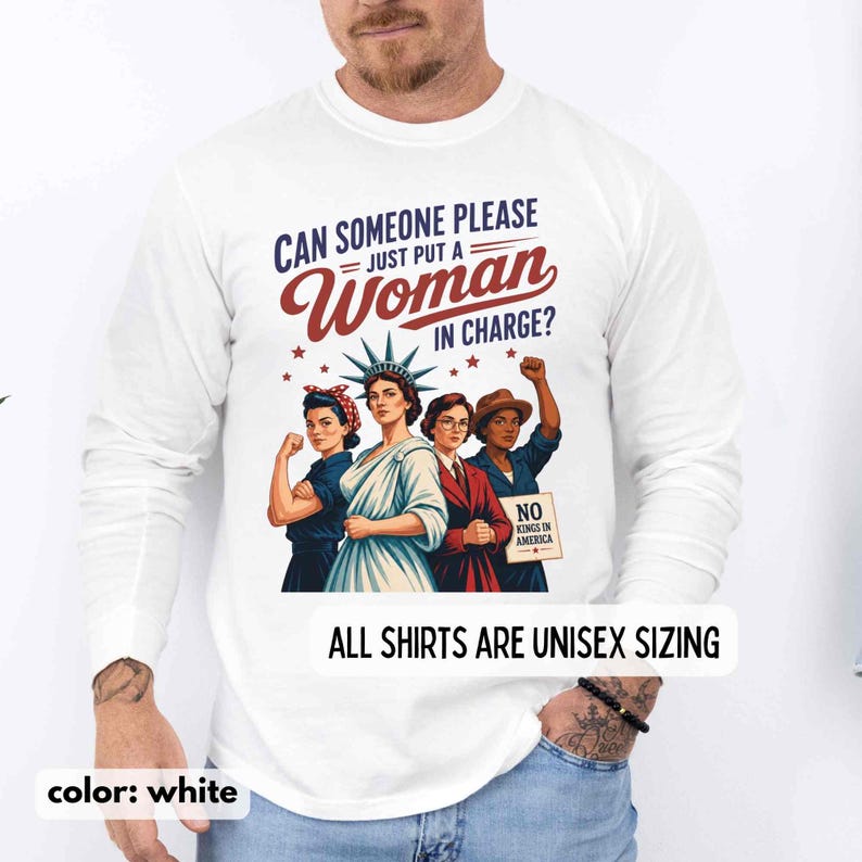 May include: White long-sleeve shirt with the text "CAN SOMEONE PLEASE JUST PUT A WOMAN IN CHARGE?" and an illustration of four women. The shirt also has the text "NO KINGS IN AMERICA" and "ALL SHIRTS ARE UNISEX SIZING".