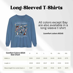 May include: A blue long-sleeved t-shirt with a graphic of Boston Terriers in a flower market. The text "The Boston Terrier Flower Market" and "Los Angeles, California Est 2023" is printed on the shirt. A size chart is included with measurements in inches.