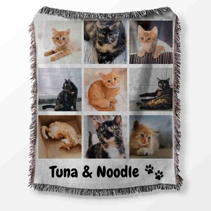 May include: A woven throw blanket with a collage of nine photos of cats. The photos are arranged in a 3x3 grid. The blanket is gray with a white fringe. The text "Tuna & Noodle" is printed on the blanket.