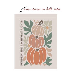 May include: A rectangular print features a stacked pumpkin design in shades of orange, peach, and tan, with green leaves and white flowers. The text "PUMPKIN SPICE & HUMAN RIGHTS" is printed vertically on the left side. The phrase "same design on both sides" is written at the top.