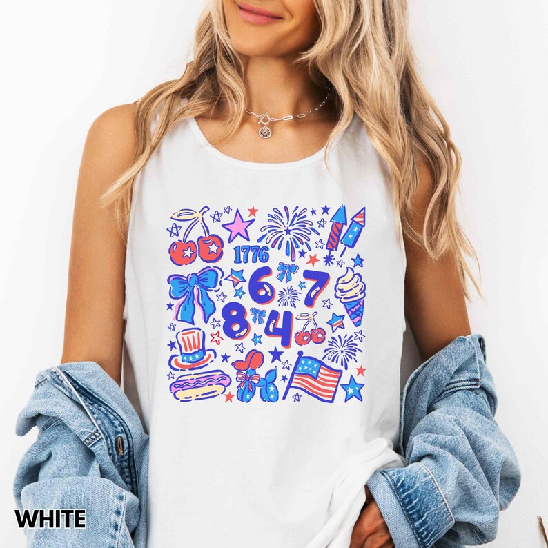 Puede incluir: Camiseta sin mangas blanca con un dise&ntilde;o gr&aacute;fico colorido que presenta s&iacute;mbolos patri&oacute;ticos como fuegos artificiales, la bandera estadounidense, estrellas y el n&uacute;mero "1776". El dise&ntilde;o incorpora colores rojo, blanco y azul, perfecto para celebraciones del D&iacute;a de la Independencia.