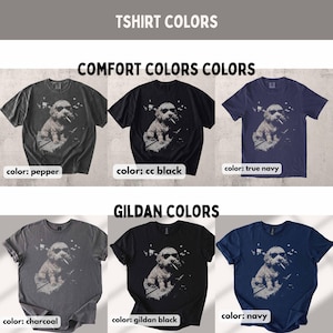 May include: A variety of t-shirts in different colors, including pepper, cc black, and true navy, are displayed. Each shirt features a graphic of a dog wearing sunglasses and smoking. The image also shows charcoal, gildan black, and navy shirts.