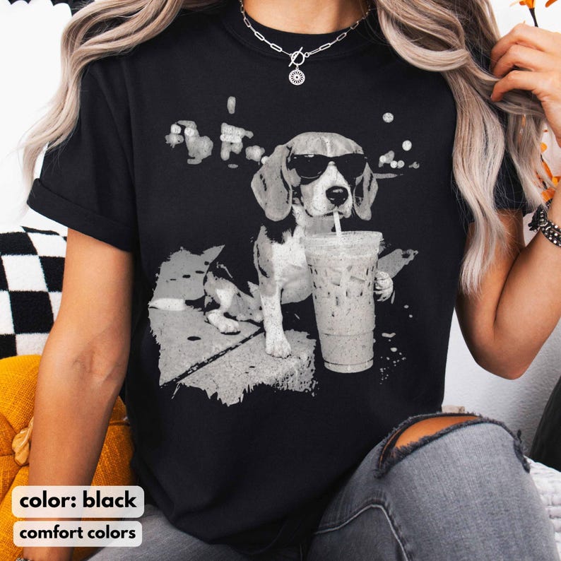 Puede incluir: Camiseta negra con un gr&aacute;fico en escala de grises de un beagle con gafas de sol y sosteniendo una bebida con pajita. El perro se representa en una pose relajada, lo que sugiere un estilo casual. Las palabras "color: black" y "comfort colors" est&aacute;n abajo.