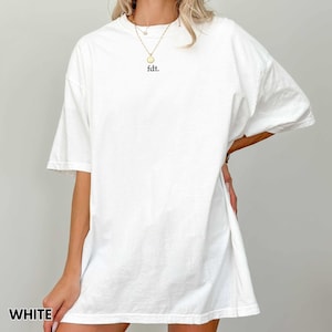 May include: White oversized t-shirt with a simple "f.d.t." text printed on the front.