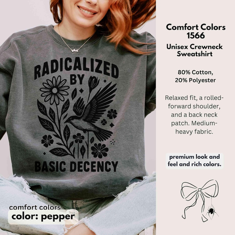 May include: Pepper-colored unisex crewneck sweatshirt with the text "RADICALIZED BY BASIC DECENCY" in black. The design includes a bird, flowers, and leaves. The sweatshirt is made of 80% cotton and 20% polyester.