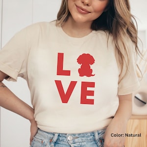 May include: A white t-shirt with the word "LOVE" printed in red. The "O" in LOVE is replaced with a red silhouette of a small dog.