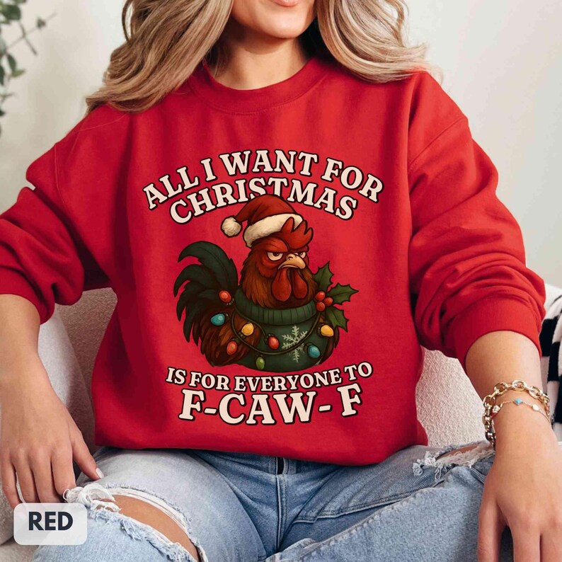 May include: Red Christmas sweatshirt with a rooster wearing a Santa hat and a string of lights. The text reads "ALL I WANT FOR CHRISTMAS IS FOR EVERYONE TO F-CAW-F".