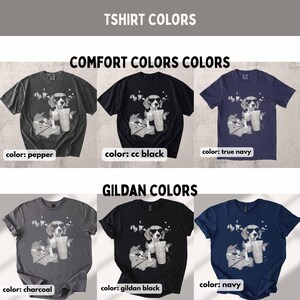 Puede incluir: Una colecci&oacute;n de camisetas en varios colores, cada una con un gr&aacute;fico de un perro con gafas de sol y sosteniendo una bebida. Las camisetas est&aacute;n disponibles en pepper, cc black, true navy, charcoal, gildan black y navy.