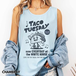 May include: Light blue tank top with the text "TACO TUESDAY" and a cartoon taco character. The tank top also has the text "now EVERYDAY at the WHITE HOUSE" and "COME FOR THE TACOS, STAY FOR THE".