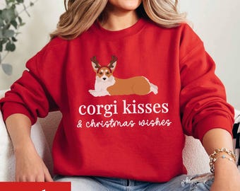 May include: Red sweatshirt with a graphic of a corgi wearing reindeer antlers and the text "corgi kisses & christmas wishes." The word "red" is in a red rectangle at the bottom. The sweatshirt is a festive holiday item.
