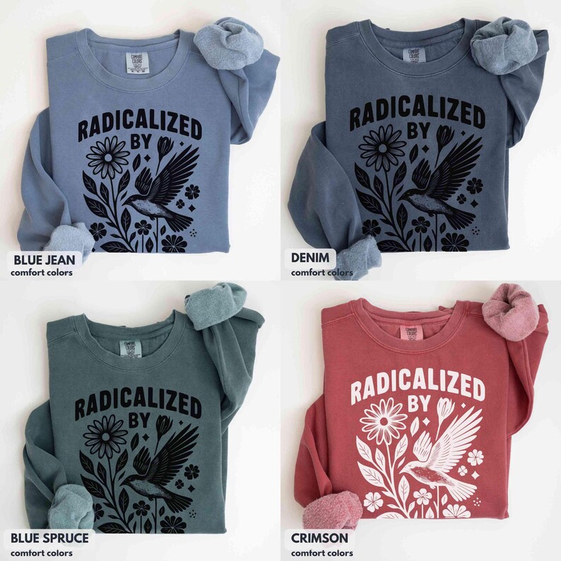 May include: Four long-sleeved sweatshirts in blue jean, denim, blue spruce, and crimson. Each shirt features the text "RADICALIZED BY" above a floral and bird graphic in black. The sleeves are cuffed with a soft, fuzzy material.