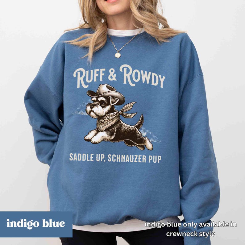 May include: Indigo blue sweatshirt with a graphic of a miniature schnauzer wearing a cowboy hat and bandana. The text "RUFF & ROWDY" and "SADDLE UP, SCHNAUZER PUP" is printed on the sweatshirt.