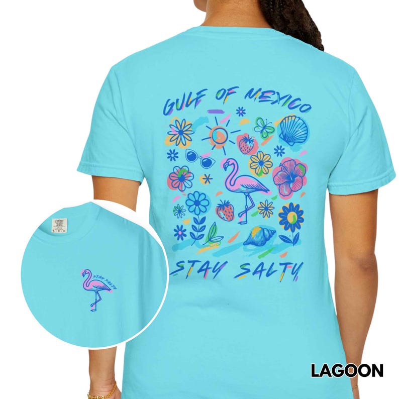 May include: A light blue t-shirt with a graphic print of a flamingo, flowers, and the text "Gulf of Mexico Stay Salty".