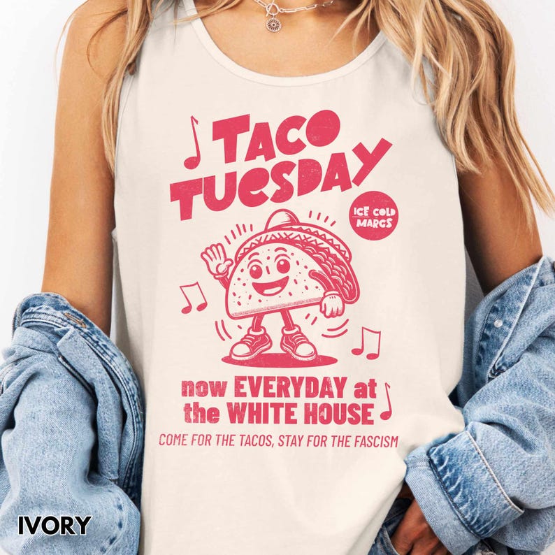 May include: Ivory tank top with a red graphic that reads "TACO TUESDAY" with a cartoon taco character and musical notes. The text "now EVERYDAY at the WHITE HOUSE" and "COME FOR THE TACOS, STAY FOR THE FASCISM" are also included.