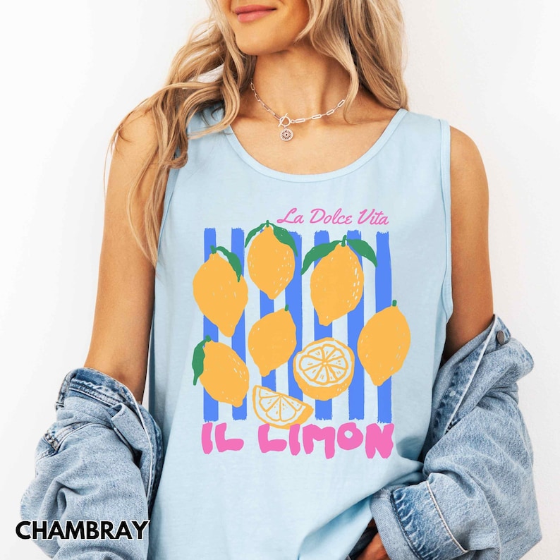 May include: Light blue tank top with a lemon graphic. The design includes yellow lemons, blue stripes, and the text "La Dolce Vita" and "Il Limon" in pink. The tank top is made of a soft material.