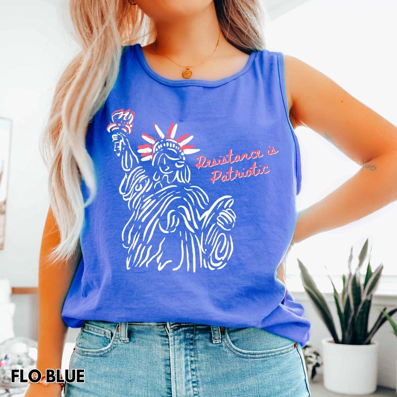 Pu&ograve; includere: Una canotta blu con un'illustrazione bianca della Statua della Libert&agrave; che tiene una torcia, con la scritta rossa "Resistance is Patriotic". La canotta &egrave; realizzata in un materiale morbido ed &egrave; di una tonalit&agrave; blu vibrante.