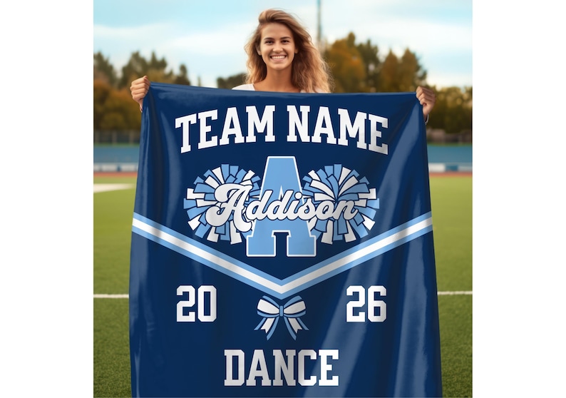 Dance Team Gifts Custom Dance Team Blanket with the team name and dance written at the top and bottom respectively in a varsity font, with the personalized dancer name in the center in between two pom poms, and with a dance team uniform stripe below it, along with a bow below the stripe, and the year arranged on each side.