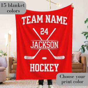 Custom Ice Hockey Blanket with the team name and hockey written at the top and bottom respectively in varsity font - along with the player name and number arranged within two crossed hockey sticks in the center