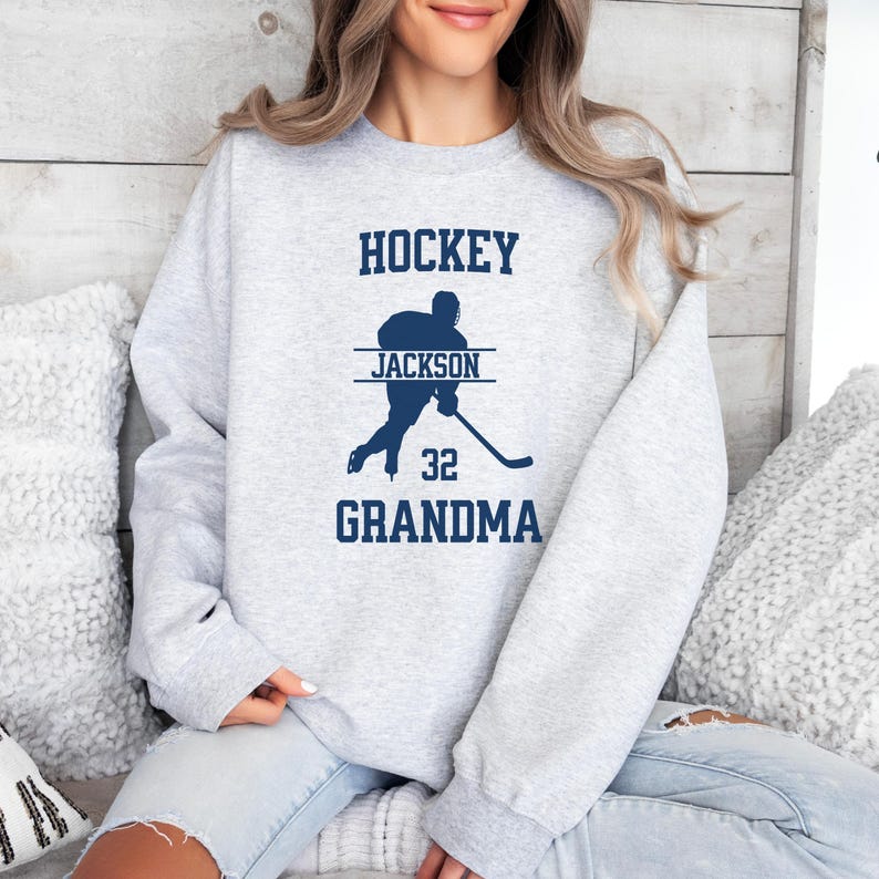May include: Gray sweatshirt with a blue hockey player graphic and the text "HOCKEY JACKSON 32 GRANDMA".