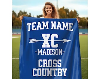 May include: A royal blue rectangular blanket featuring white printed text that reads TEAM NAME, XC with an arrow graphic, MADISON, and CROSS COUNTRY. The design is centered on the fabric, which is displayed in a vertical orientation.