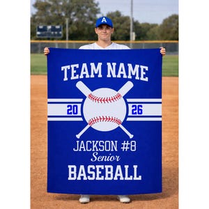 May include: A blue baseball banner with white text and graphics. The banner reads "TEAM NAME" at the top, with a baseball and crossed bats in the center. Below, it says "JACKSON #8 Senior BASEBALL". The numbers "20" and "26" are also displayed.