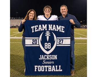 May include: A rectangular navy blue fleece blanket featuring white text and graphics. The design includes the words TEAM NAME, JACKSON, Senior, and FOOTBALL, along with the numbers 20, 27, and 88, and a central graphic of a stylized football.