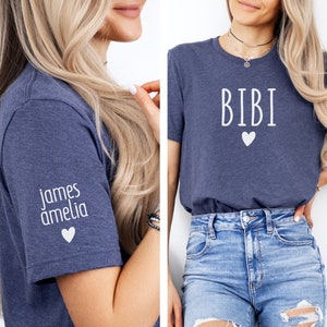 May include: Two navy blue t-shirts with white text. One shirt says "BIBI" with a white heart. The other shirt says "james amelia" with a white heart.