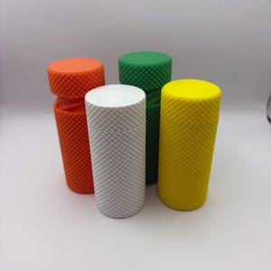 May include: Four cylindrical knobs in orange, white, green, and yellow. Each knob has a textured diamond pattern.