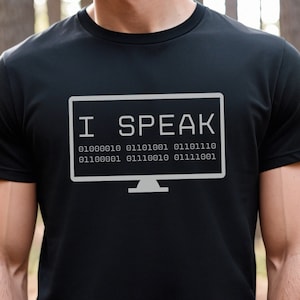 May include: Black t-shirt with a white graphic of a computer screen that says "I SPEAK" and a line of binary code.