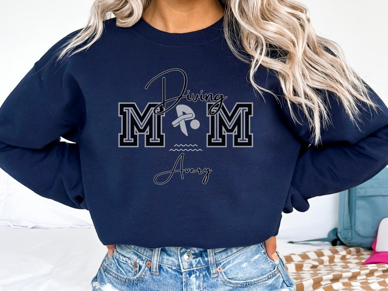 Navy colored sweatshirt featuring the phrase "Diving Mom " and illustrated with a diver. Includes a place to add your diver's name