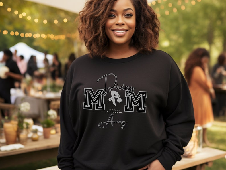 Black colored sweatshirt featuring the phrase "Diving Mom " and illustrated with a diver. Includes a place to add your diver's name