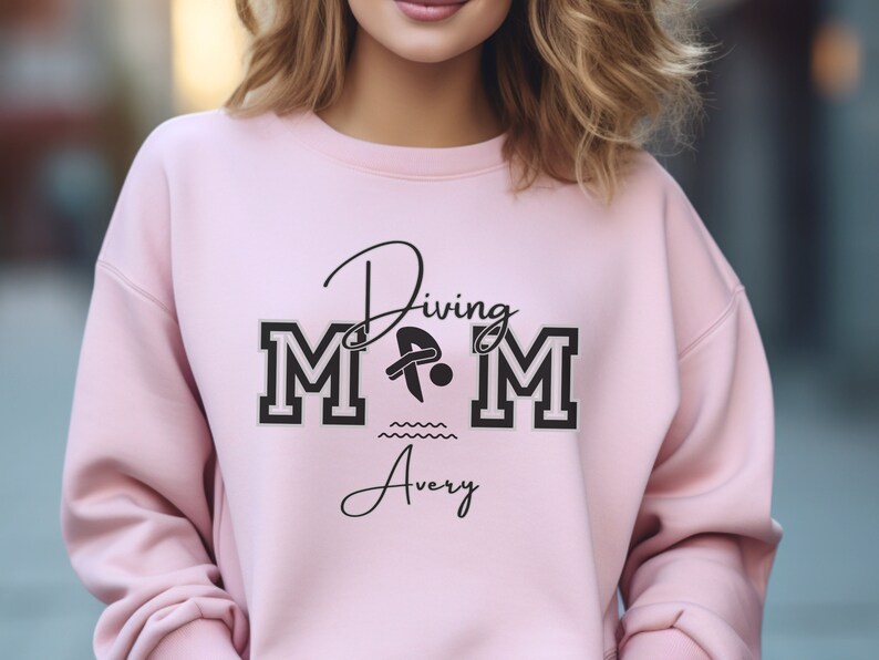 Light Pink colored sweatshirt featuring the phrase "Diving Mom " and illustrated with a diver. Includes a place to add your diver's name