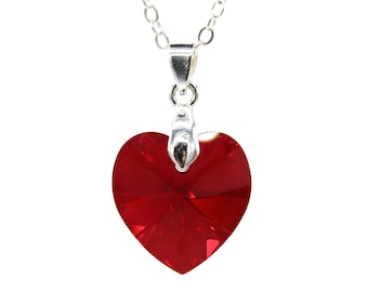 Pode incluir: Um colar de corrente de prata com um pingente de coração de cristal vermelho.