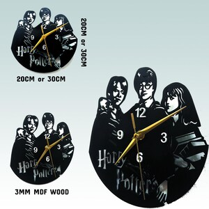May include: Black and white clock featuring a silhouette of Harry Potter, Ron Weasley, and Hermione Granger. The clock is made of 3mm MDF wood and is available in 20cm or 30cm sizes. The clock face has gold hands and black numbers.