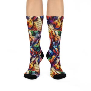 May include: A pair of colourful socks with a pattern of violins and sheet music. The socks are black with a colourful abstract design.