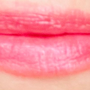 Pu&ograve; includere: Primo piano di labbra con un rossetto rosa chiaro.